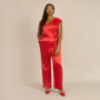 Yes, plus size women can wear jumpsuits. Woman wearing red plus size jumpsuit.