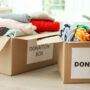 Donation boxes with clothes on floor indoors