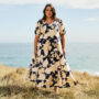 Plus size woman wearing navy and floral maxi dress.